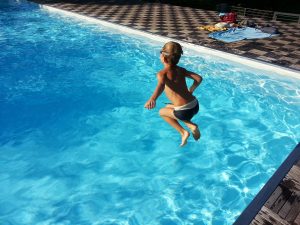 salt water pool vs chlorine, child jumping into pool